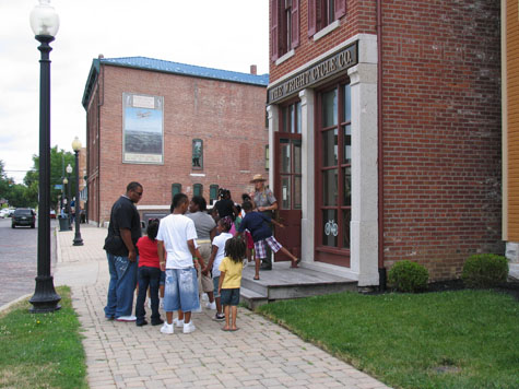 Ranger and visiting students stop by the Wright bike shop.