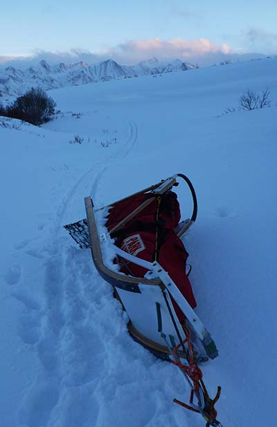 snowy landscape and a sled turned on its side
