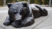 a bronze sculpture of a bear lying down