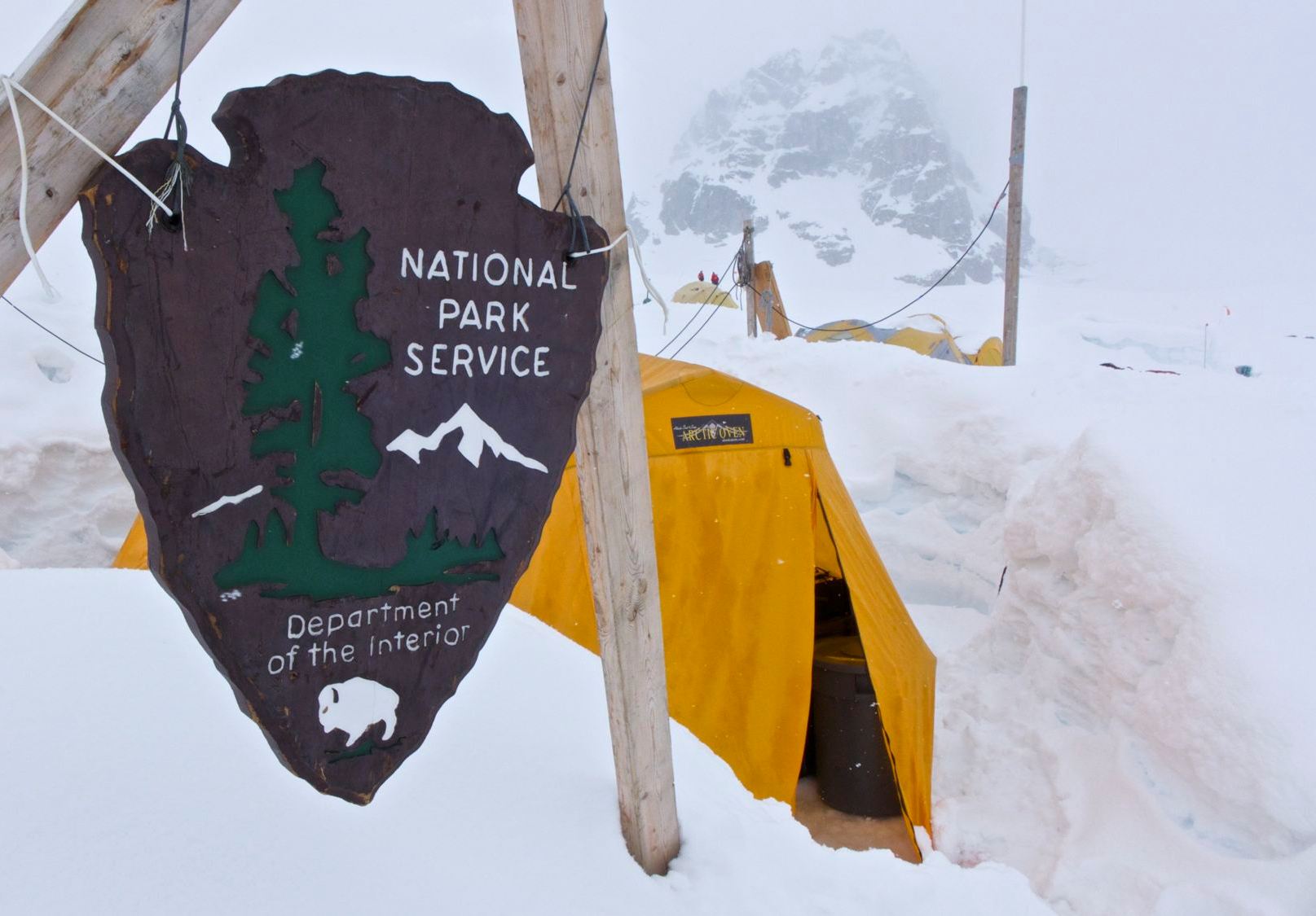 An NPS Arrowhead plaque demarks the location of the snowy ranger camp