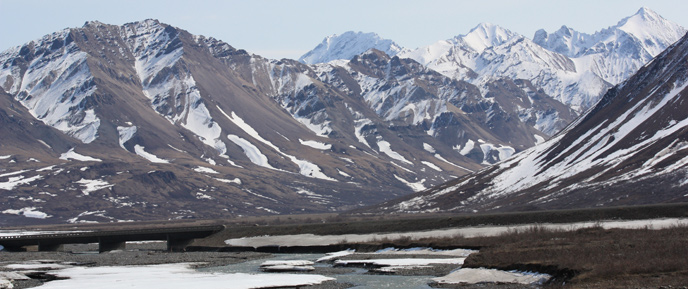 Image of river, bridge and mountains in early (snowy) spring