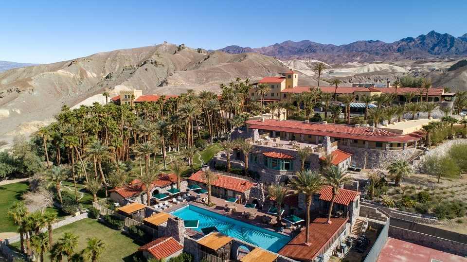 This aerial photograph of The Inn at Death Valley shows the pool in the foreground and the historic hotel in the background.
