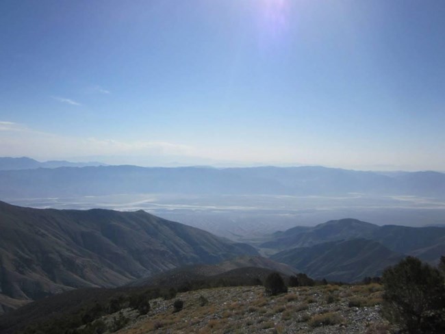 View into a valley with salt flats and mountain ranges