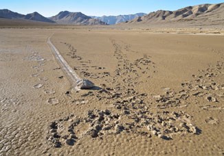 Unfortunate footprints in the soft muddy surface of Racetrack playa surround one of the "moving rocks".