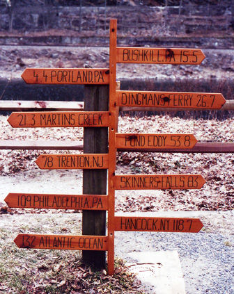 A sign with arrows and mileage to variouspoints along the river.