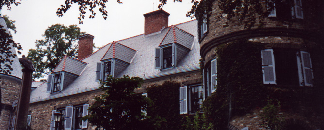 A large stone mansion with a turret