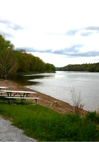 A river shoreline with picnic benches