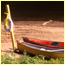 Canoes and a life-saving ring  on a beach along a river