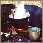 a kettle boiling on an outdoor fire