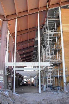 The exhibit hall with new white steel wind columns and the steel framework for the mezzanine visible. 