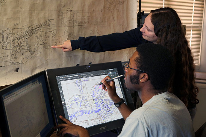 Using digitizing monitors and GIS software interns Nicole and Ben are converting and merging old quarry paper maps into a single electronic master map of one of the world's greatest dinosaur quarries.