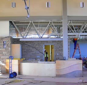 View of the interior of the visitor center showing the new wood information desk and stone work behind it. 