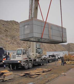Large air handling unit being lifted off flatbed truck.