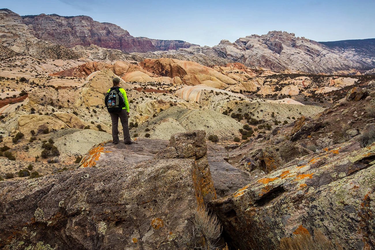 Hiker and Split Mountain Person standing among widely colored rock layers