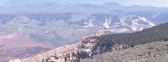 View across plateau to colorful rocks in distance.
