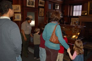 Family in Thomas Edison's library, listening to a Park Ranger present a program.