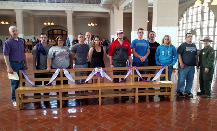 Hammondsport students and supporters stand with their bench in the Great Hall at Ellis Island.
