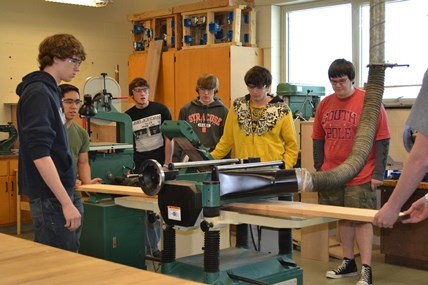 Seven Campbell-Savona High School students help to prepare lumber to be used as part of a replica bench.