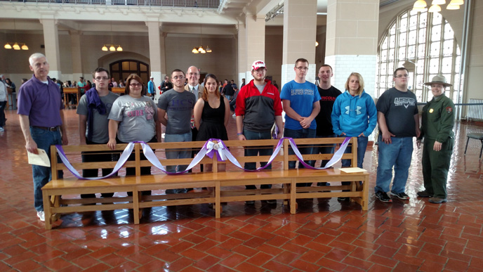 Hammondsport student's stand with their bench in the Great Hall at Ellis Island