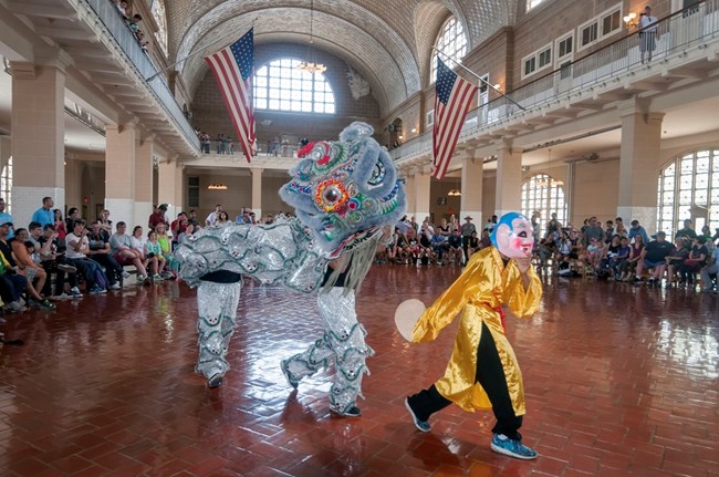 Ellis Island Asian Pacific Heritage event, performers are in costume with a crowd of visitors watching