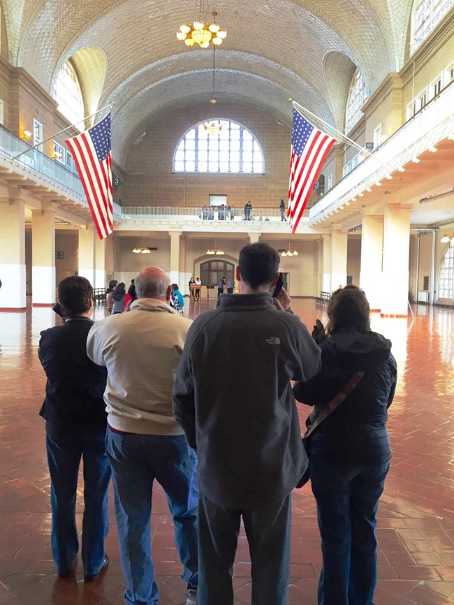 Visitors with an audio tour in the Great Hall on Ellis Island