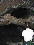 A hiker views lava tubes in Four Windows Cave.
