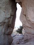 A keyhole arch is located in a sandstone cliff.