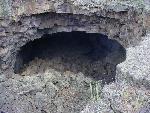 A cave entrance in black lava
