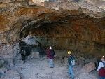 Hikers examine the arched roof of a cave