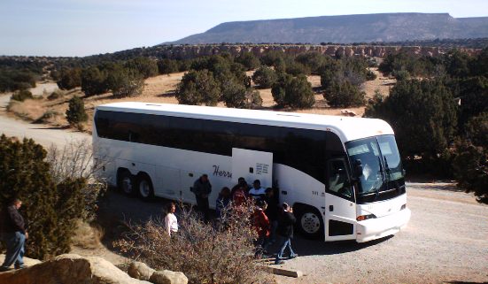 A tour bus unloads visitors at Sandstone Bluffs