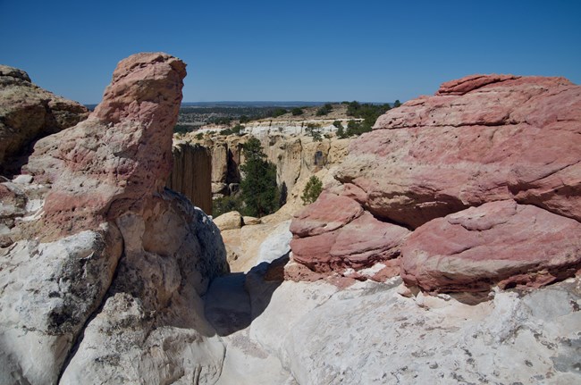 A reddish rock formation overlays a paler bedrock