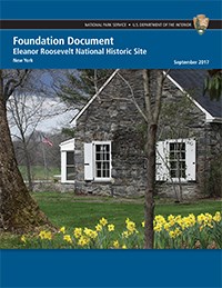 A report cover with image of stone house on green lawn with daffodils.