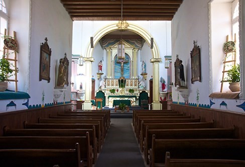 image of altar, a cross in the middle, and wooden seats