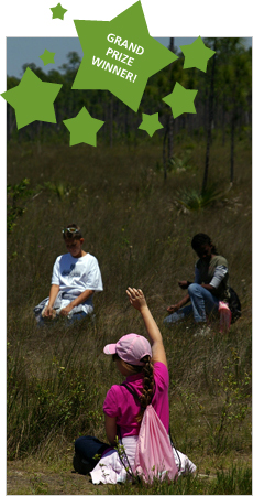 After listening to nature sounds, a student raises her hand to share what she heard.