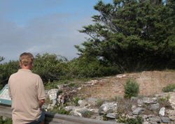 Man peers over foundation of 1826 Fire Island Lighthouse.