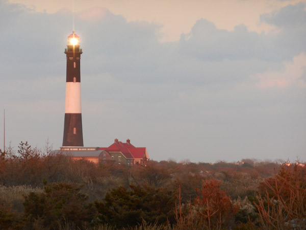 Fire Island Lighthouse tower with pink glow from setting sun.