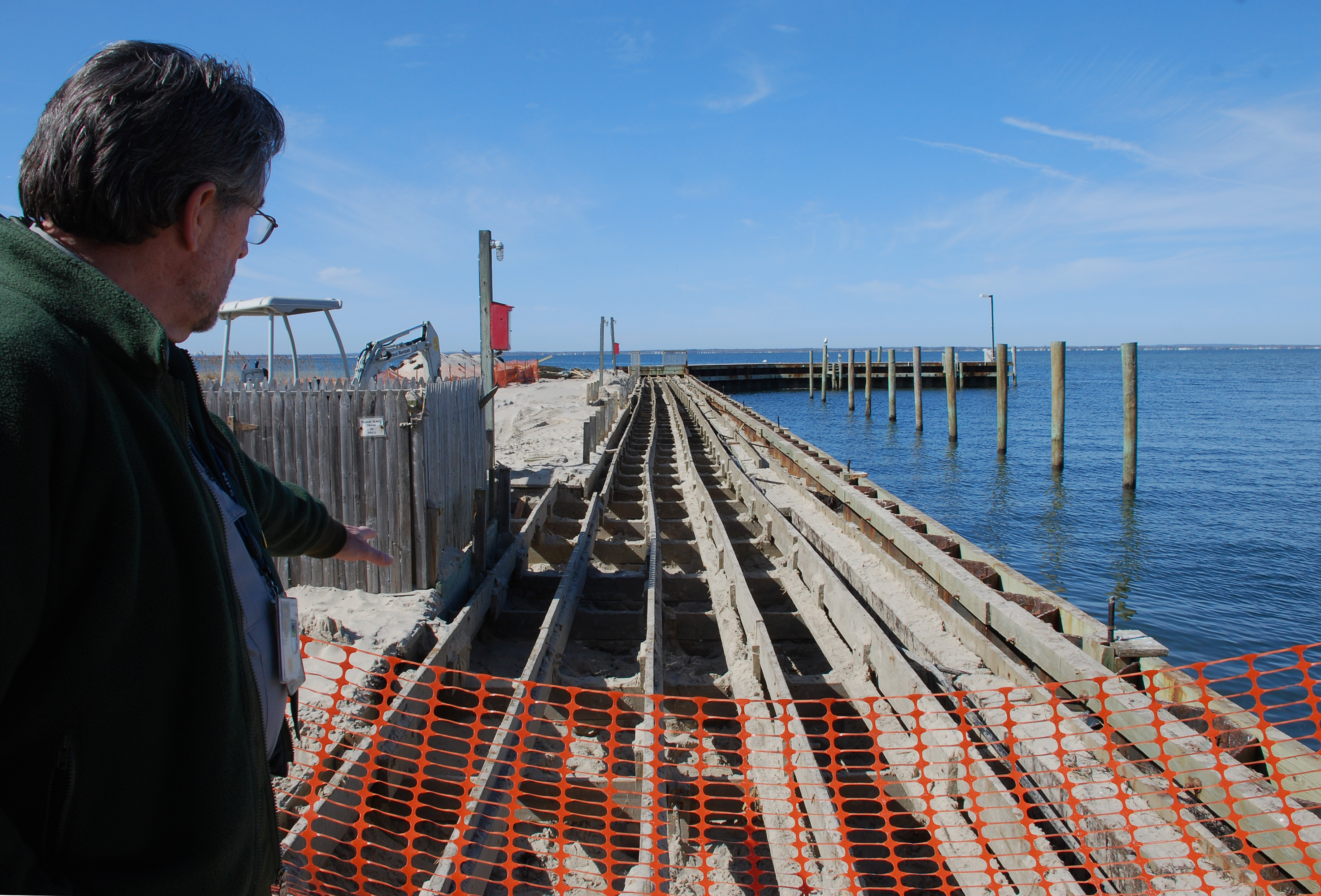 Superintendent Chris Soller points to substructure of Sailors Haven marina.