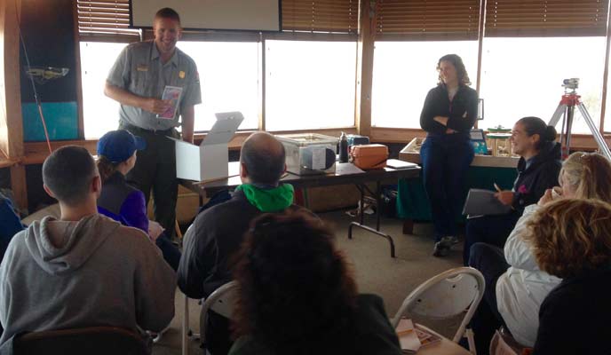 A park ranger introduces an educational activity to a group of teachers.