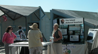 Small group talking in front of outdoor exhibit.