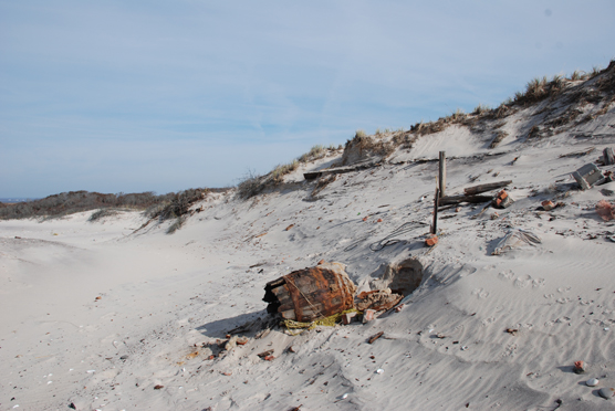 Deteriorating barrel and other remnants of old beach house uncovered in the dunes.
