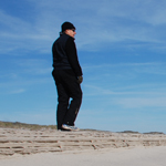 Hiker on beach dressed for winter.
