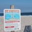 Rip current sign posted along the beach.