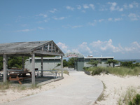 Curving boardwalk winds past small picnic shelter and bath house.