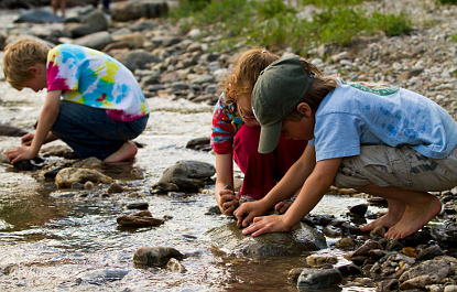 Three kids kids exploring stream