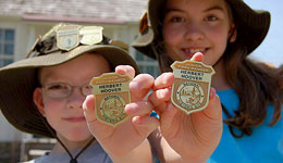 Two kids show their Junior Ranger badges