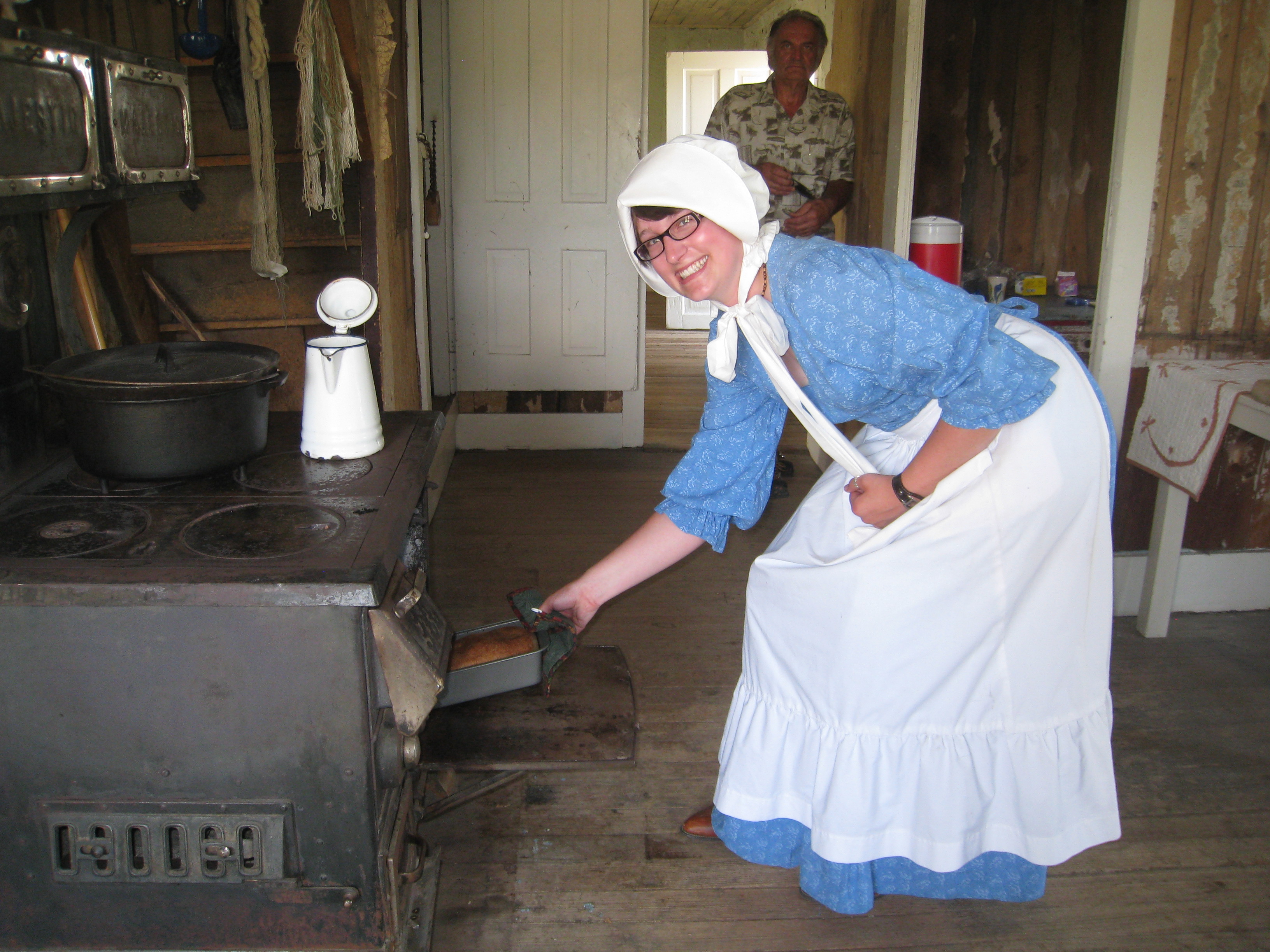 Park staff, dressed in late 1800s clothing, prepare fresh bread in the woodstove