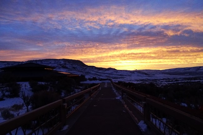 Sunrise over Fossil Butte. Pathway leading down towards the butte with the visitors center on the left.