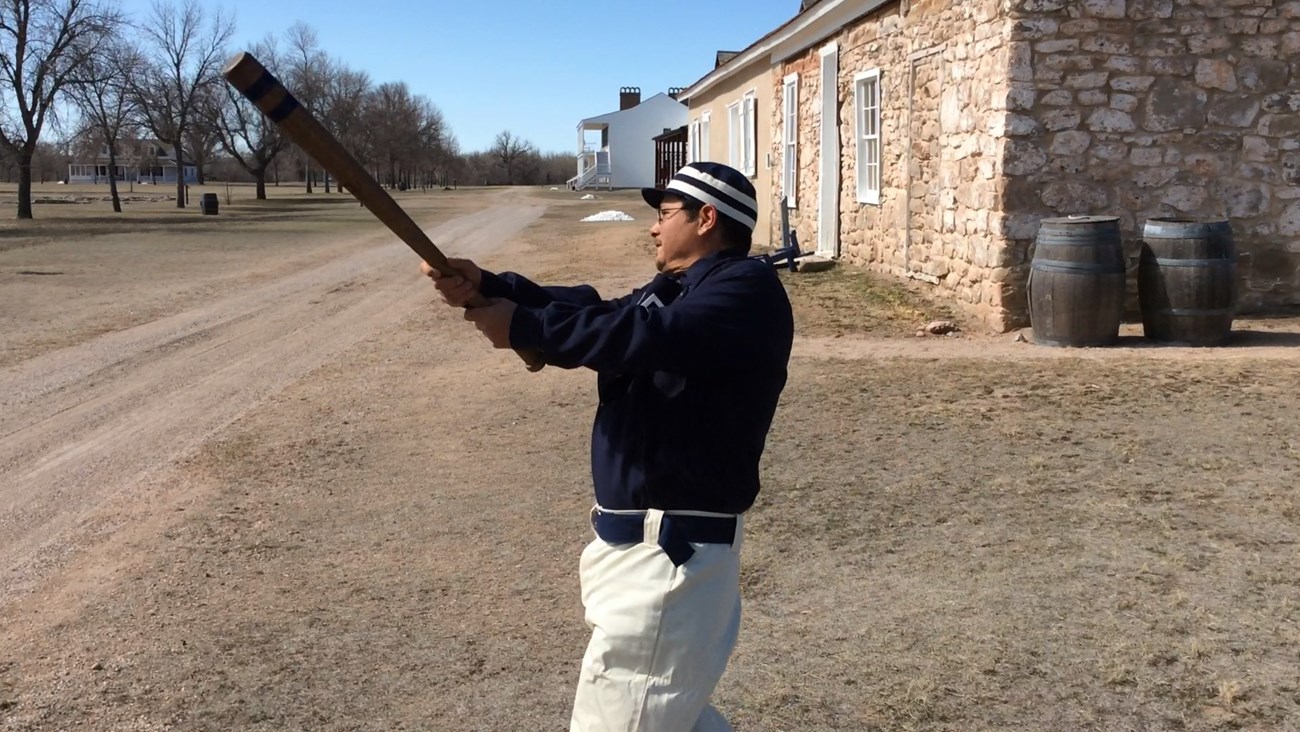 Ranger Eric swinging a 19th century baseball bat in a 19th century uniform.