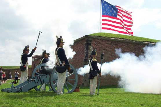 The Fort McHenry Guard fires a cannon as the Garrison Flag flies over the fort.