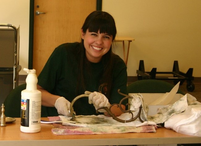 A volunteer cleans an artifact
